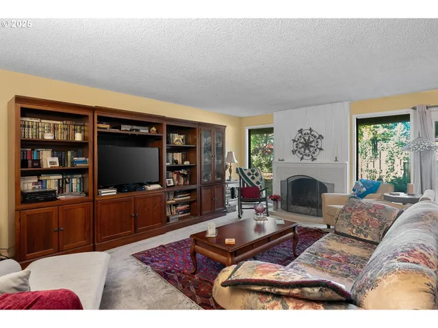 a living room with furniture a flat screen tv and a fireplace