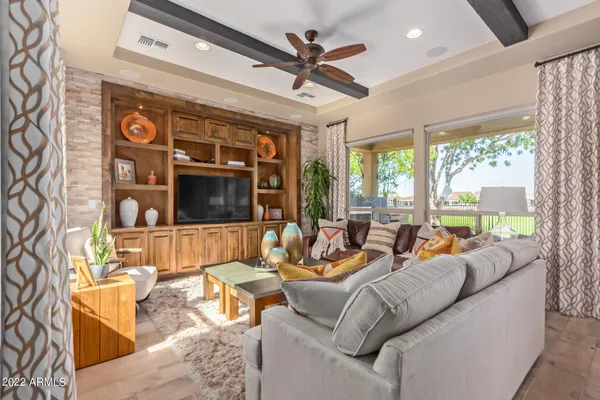 a living room with furniture a ceiling fan and a large window