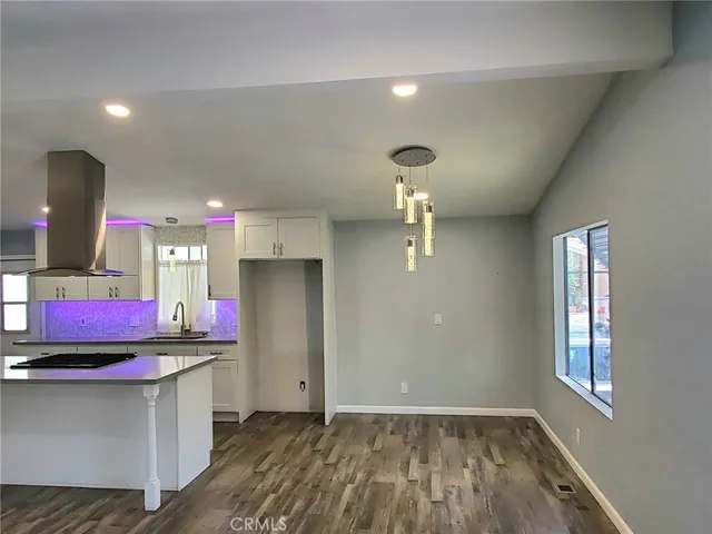 a kitchen that has a lot of cabinets and stainless steel appliances