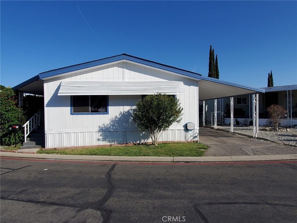 27361 Sierra Highway, Unit 19 Canyon Country, CA 91351 - Photo 2 of 26 a front view of a house with a garden and yard