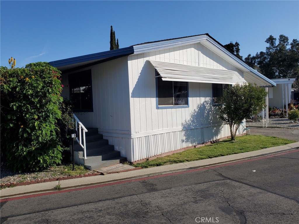 27361 Sierra Highway, Unit 19 Canyon Country, CA 91351 - Photo 3 of 26 a front view of a house with a yard