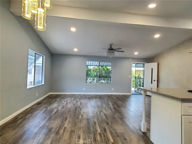 a kitchen with kitchen island granite countertop wooden floor and stainless steel appliances