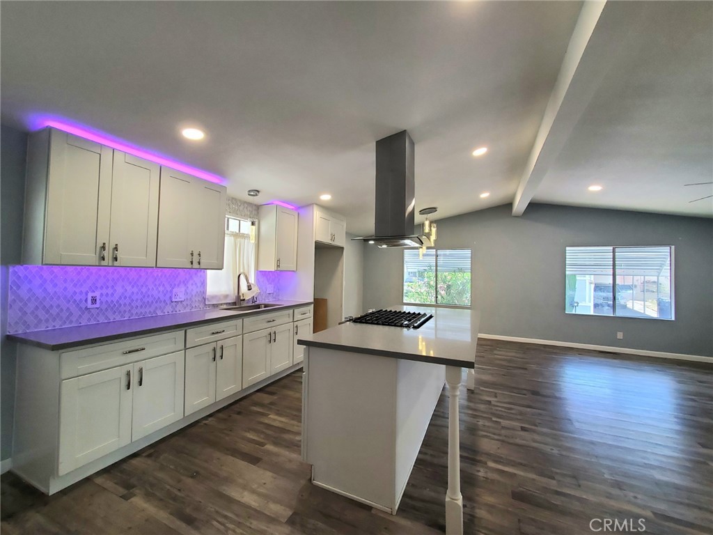 27361 Sierra Highway, Unit 19 Canyon Country, CA 91351 - Photo 10 of 26 a kitchen with kitchen island granite countertop wooden floor and stainless steel appliances