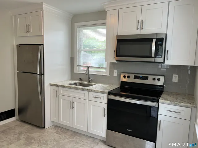 a kitchen with white cabinets and stainless steel appliances