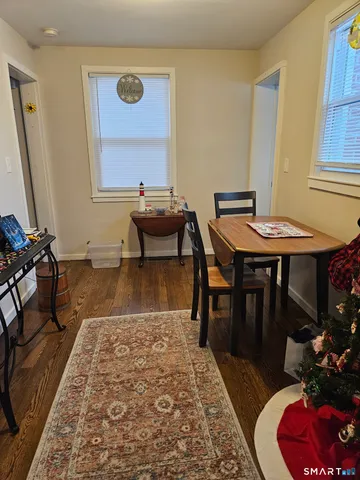 a living room with table chairs and a rug