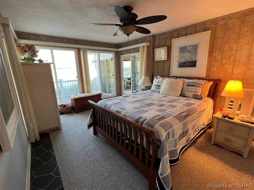 790 Long Point Lane Topping, VA 23169 - Photo 13 of 26 Carpeted bedroom featuring ceiling fan and wooden walls