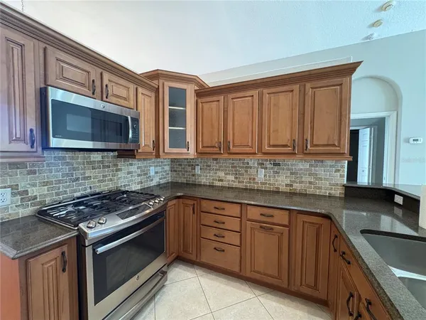 a kitchen with stainless steel appliances granite countertop a stove microwave and cabinets