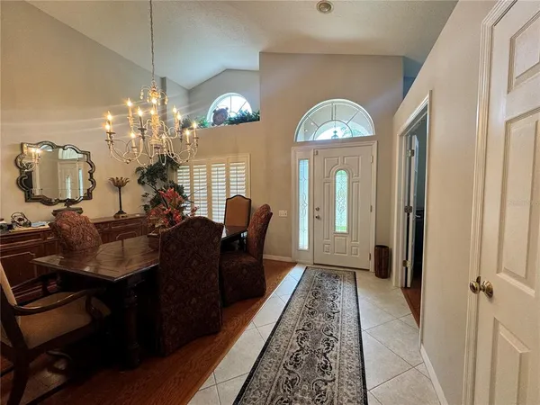 a living room with furniture chandelier and a mirror