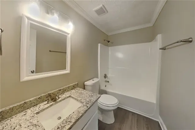 a view of a small white house with a large tree