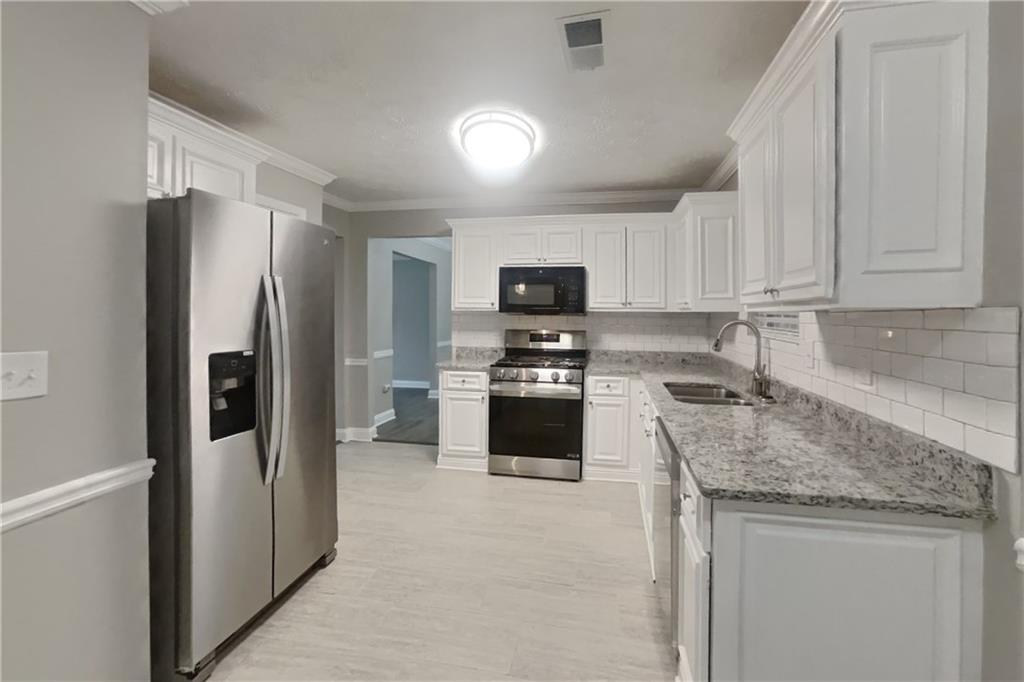 2958 Arden Ridge Terrace Suwanee, GA 30024 - Photo 4 of 20 a kitchen with a refrigerator stove and sink