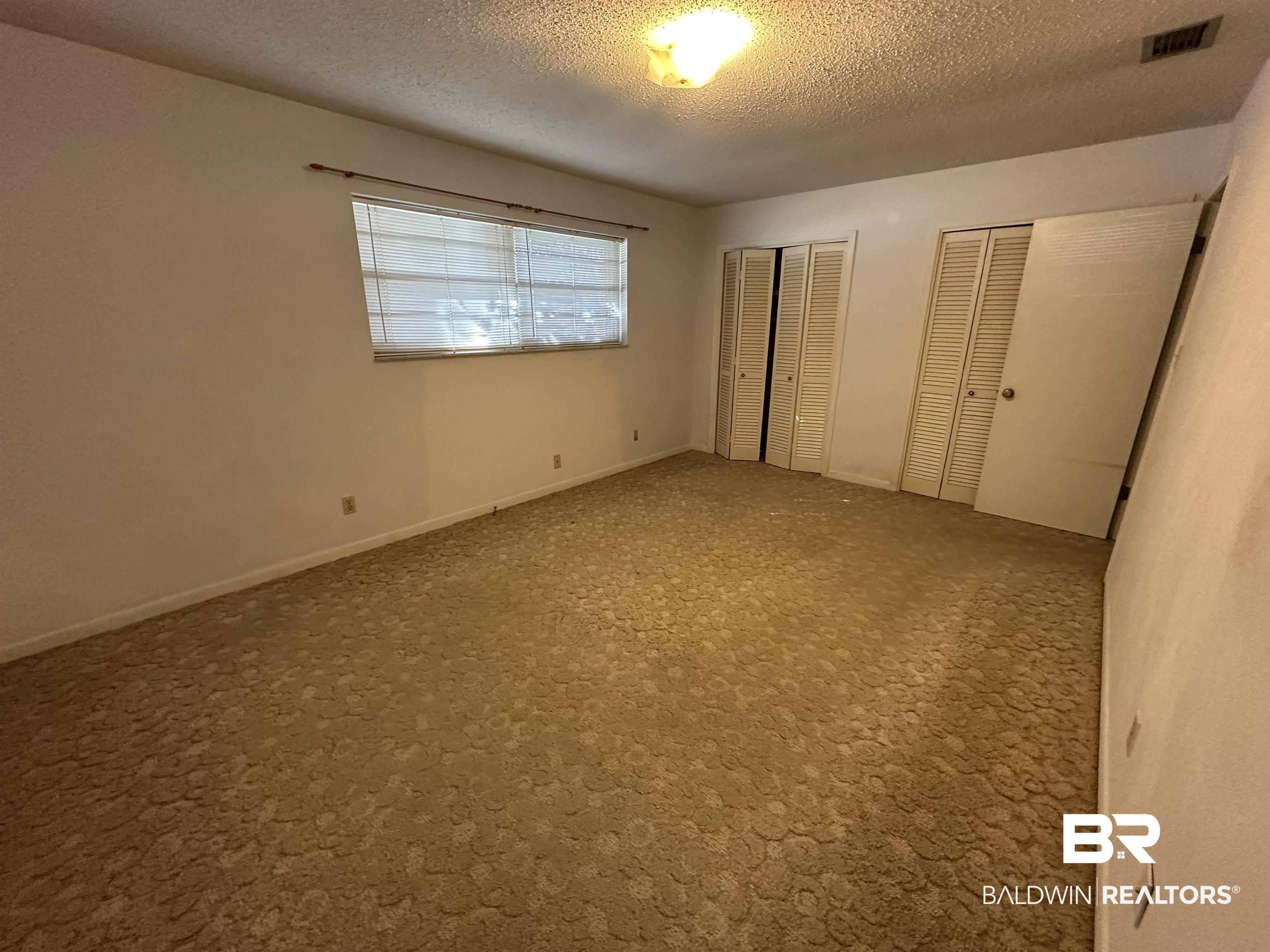 1 Yupon Circle Foley, AL 36535 - Photo 15 of 30 Unfurnished bedroom with multiple closets, carpet, and a textured ceiling