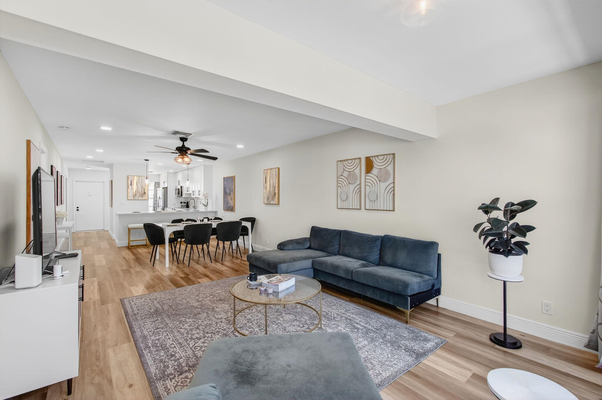 2825 Southwest 13th Street, Unit 204 Delray Beach, FL 33445 - Photo 13 of 62 a living room with furniture a chandelier and a flat screen tv