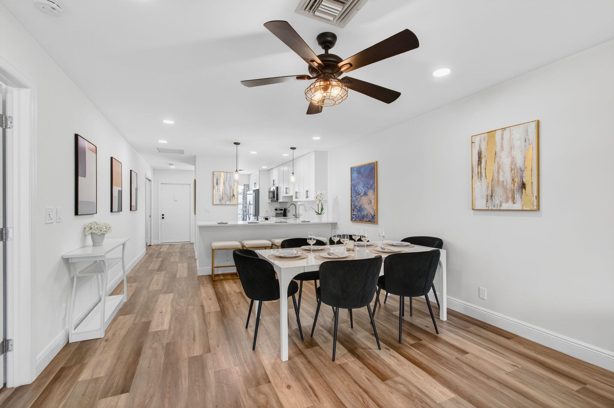 2825 Southwest 13th Street, Unit 204 Delray Beach, FL 33445 - Photo 16 of 62 a view of a dining room and livingroom with furniture wooden floor a rug a painting and a chandelier
