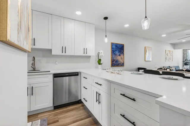 a kitchen with white cabinets and sink