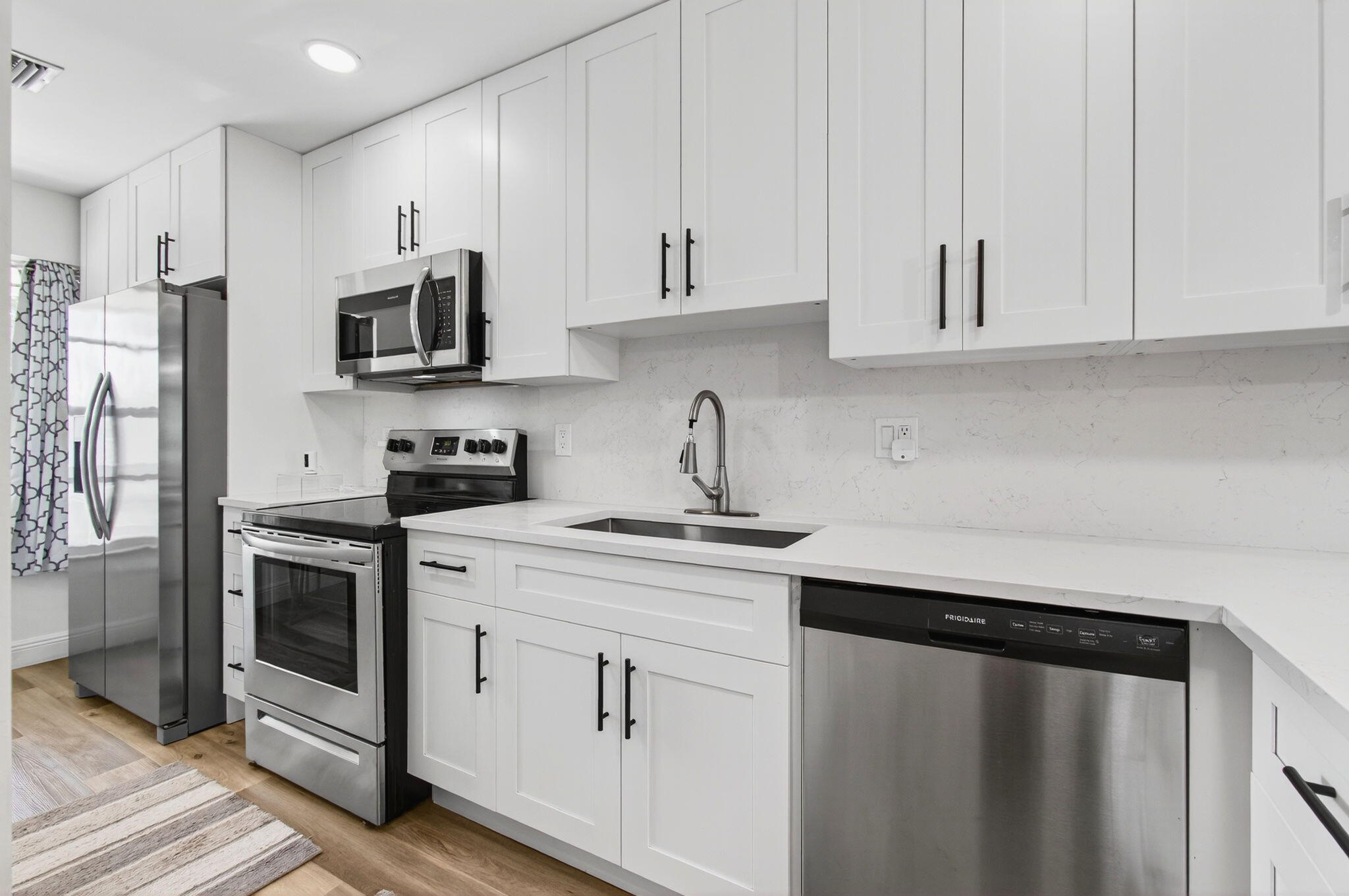 2825 Southwest 13th Street, Unit 204 Delray Beach, FL 33445 - Photo 19 of 62 a kitchen with stainless steel appliances white cabinets and a sink
