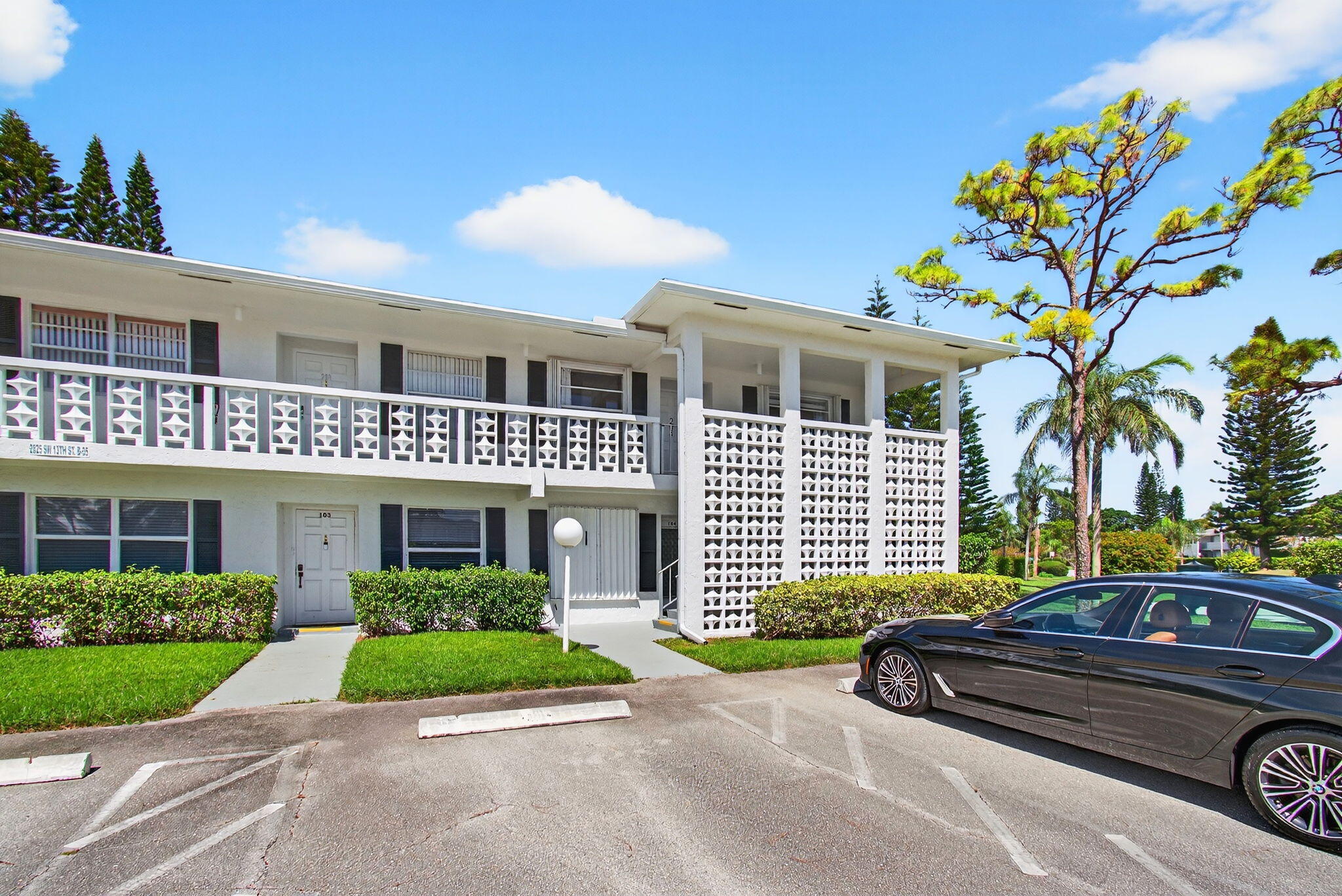 2825 Southwest 13th Street, Unit 204 Delray Beach, FL 33445 - Photo 2 of 62 a front view of a house with a garden and plants