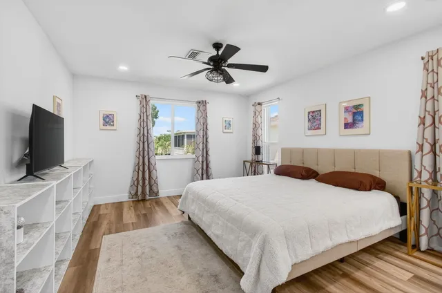 a bedroom with a bed a window and a chandelier