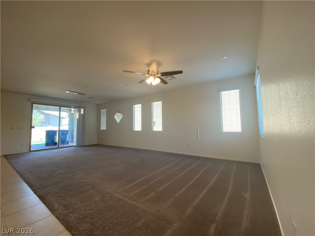 436 Cadence View Way Henderson, NV 89011 - Photo 6 of 36 A spacious living room featuring carpeted floors and a sliding glass door leading to the outdoors.