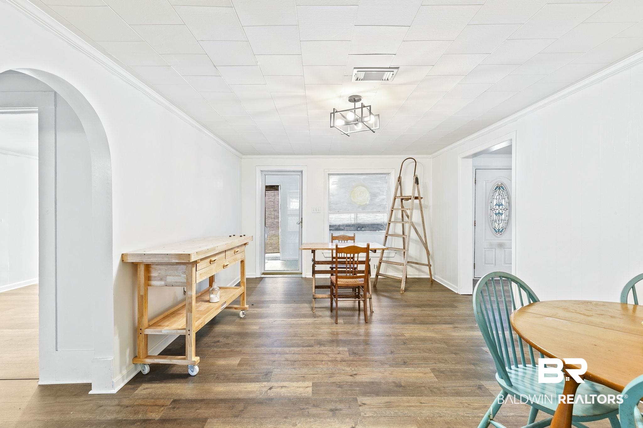 316 West Orchid Avenue Foley, AL 36535 - Photo 14 of 38 Dining space featuring arched walkways, crown molding, and wood finished floors