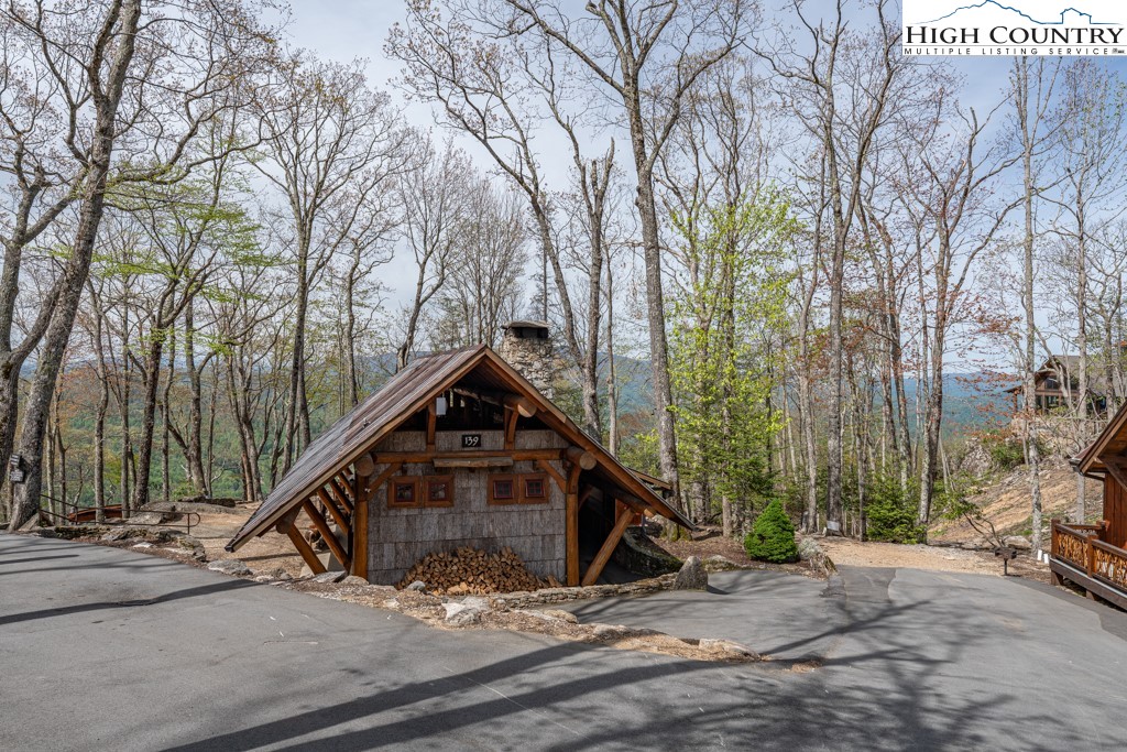 77 Eagles Nest Trail Banner Elk, NC 28604 - Photo 28 of 44 a view of a wooden house with a large windows and a large tree in the background