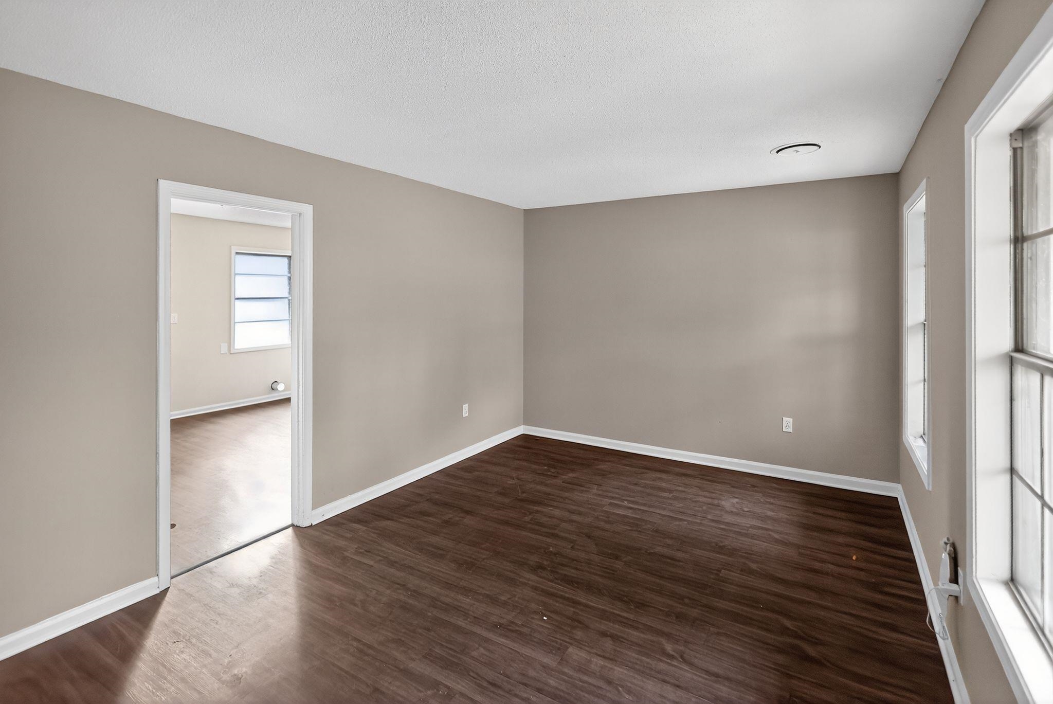 3860 Castleman Street Memphis, TN 38118 - Photo 18 of 30 a view of an empty room with wooden floor and a window