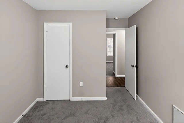 an empty room with closet and windows