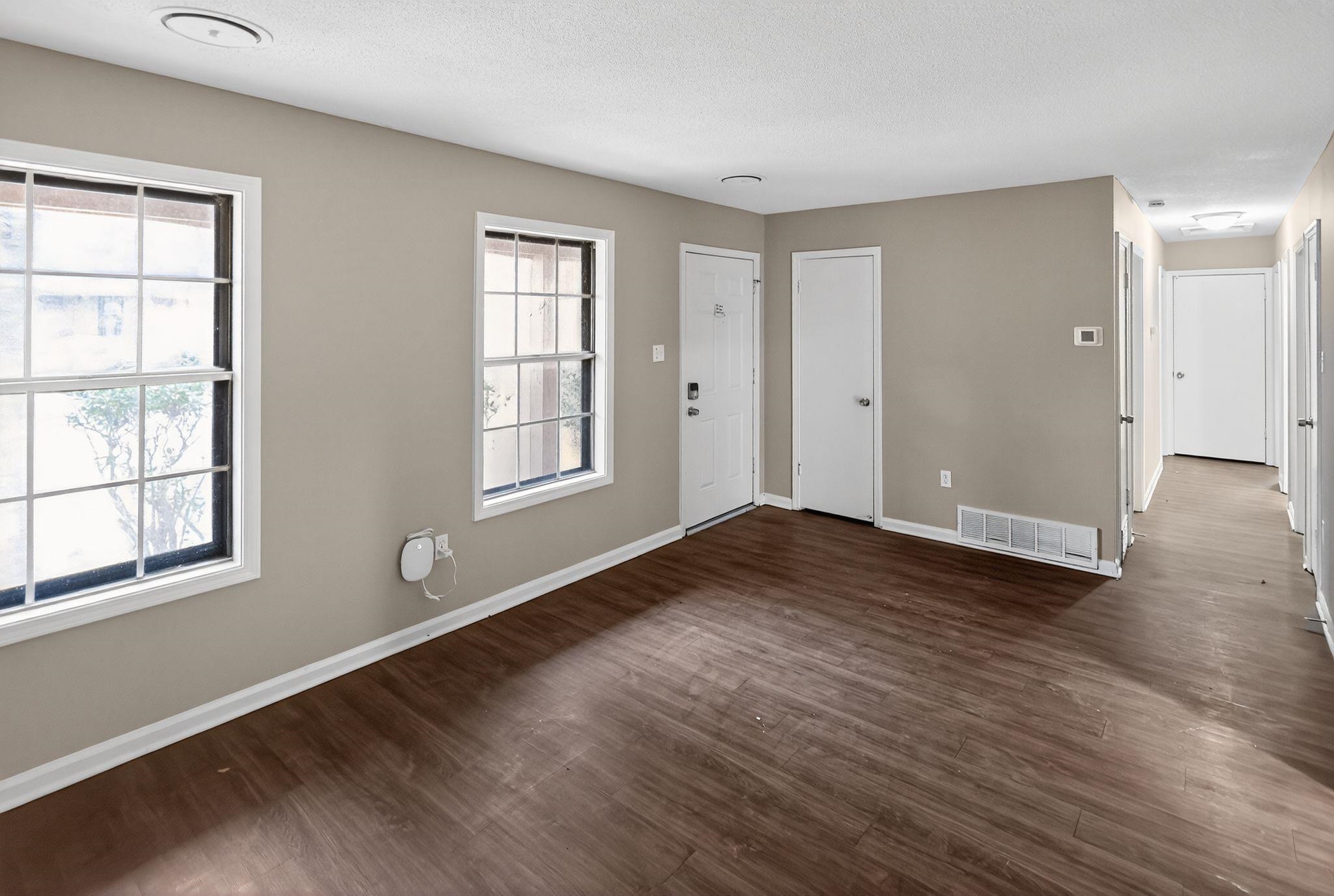 3860 Castleman Street Memphis, TN 38118 - Photo 8 of 30 an empty room with wooden floor and windows