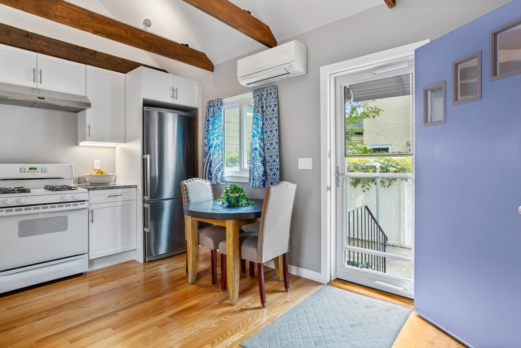 89 Prospect Street Somerville, MA 02143 - Photo 11 of 21 a kitchen with a table chairs refrigerator and cabinets