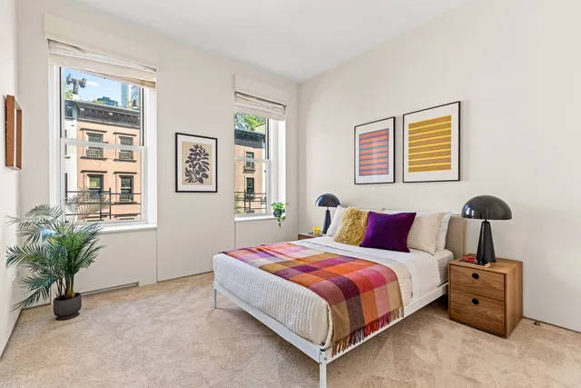 a bedroom with a bed and a potted plant