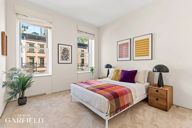 a bedroom with a bed and a potted plant