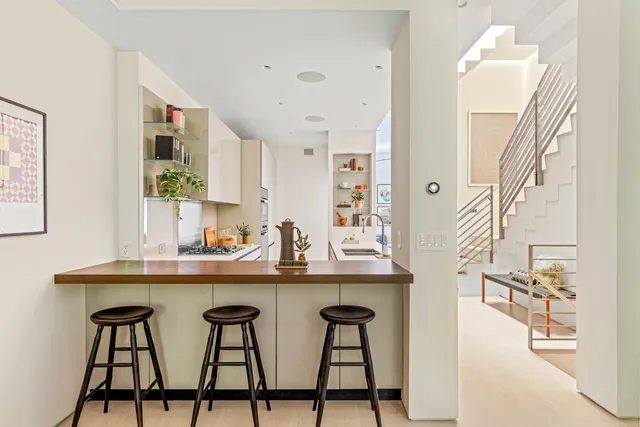 a kitchen with stainless steel appliances granite countertop a sink and chairs in it