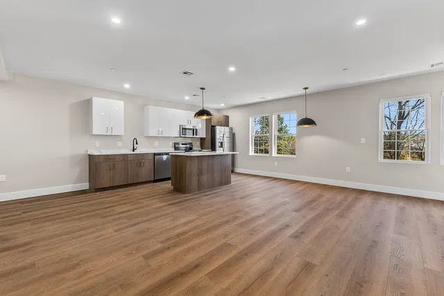 a view of a kitchen with furniture and wooden floor