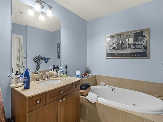 a bathroom with a tub a sink and mirror