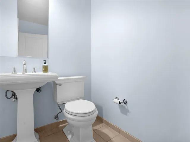 a bathroom with a sink toilet and a mirror