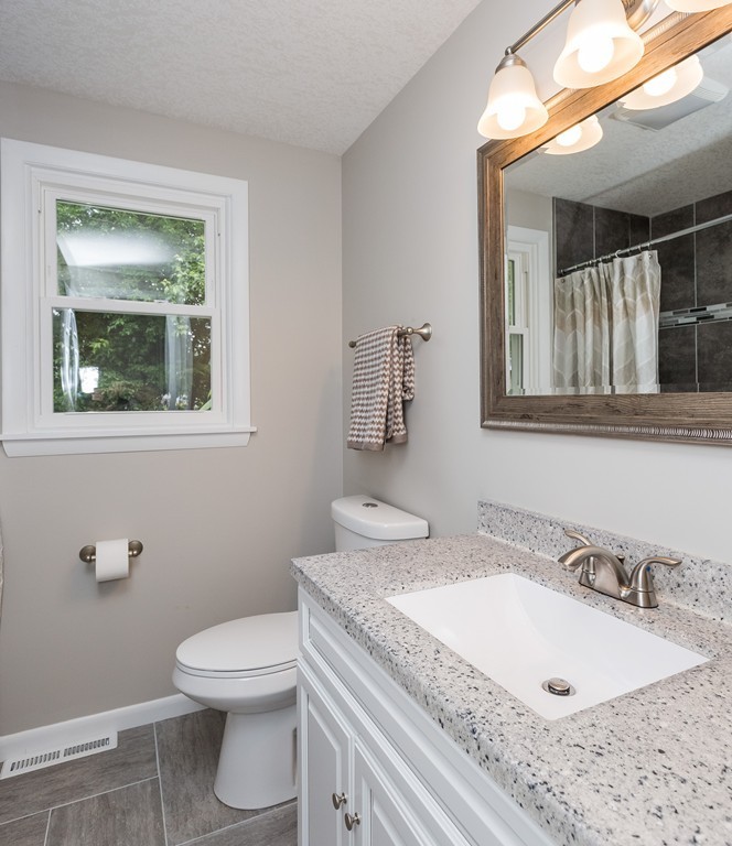 29 Mary Coburn Road Springfield, MA 01129 - Photo 15 of 30 a bathroom with a granite countertop toilet a sink and mirror