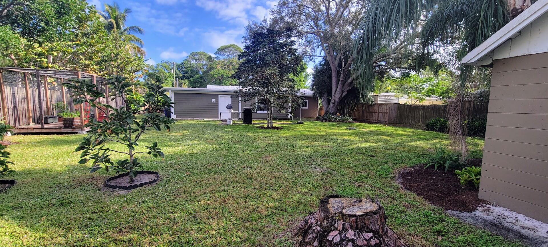 5002 Southeast Capstan Avenue Stuart, FL 34997 - Photo 4 of 20 a view of a backyard with potted plants and large tree