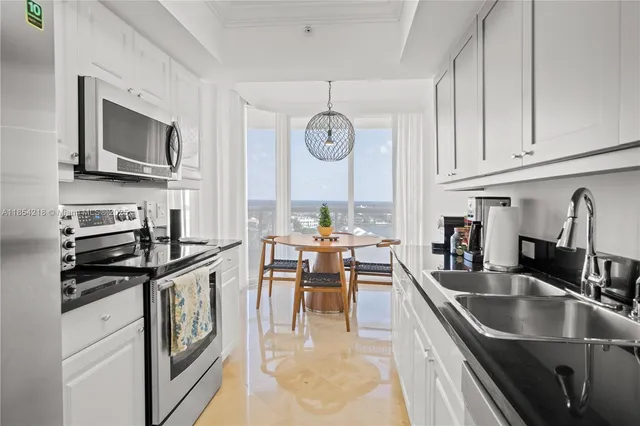 a kitchen with stainless steel appliances granite countertop a sink dishwasher a stove microwave and refrigerator with wooden floor