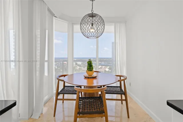 a view of a dining room with a table and chairs