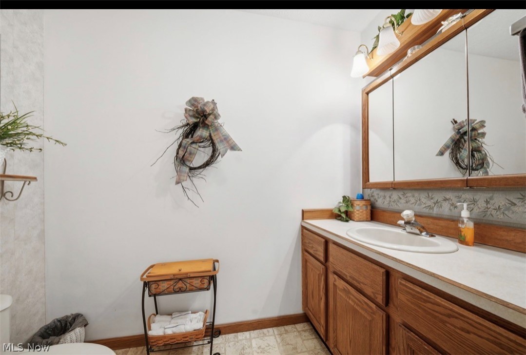 3556 Lake Road Conneaut, OH 44030 - Photo 33 of 39 Bathroom featuring a wood-finish vanity with a white countertop and an integrated sink