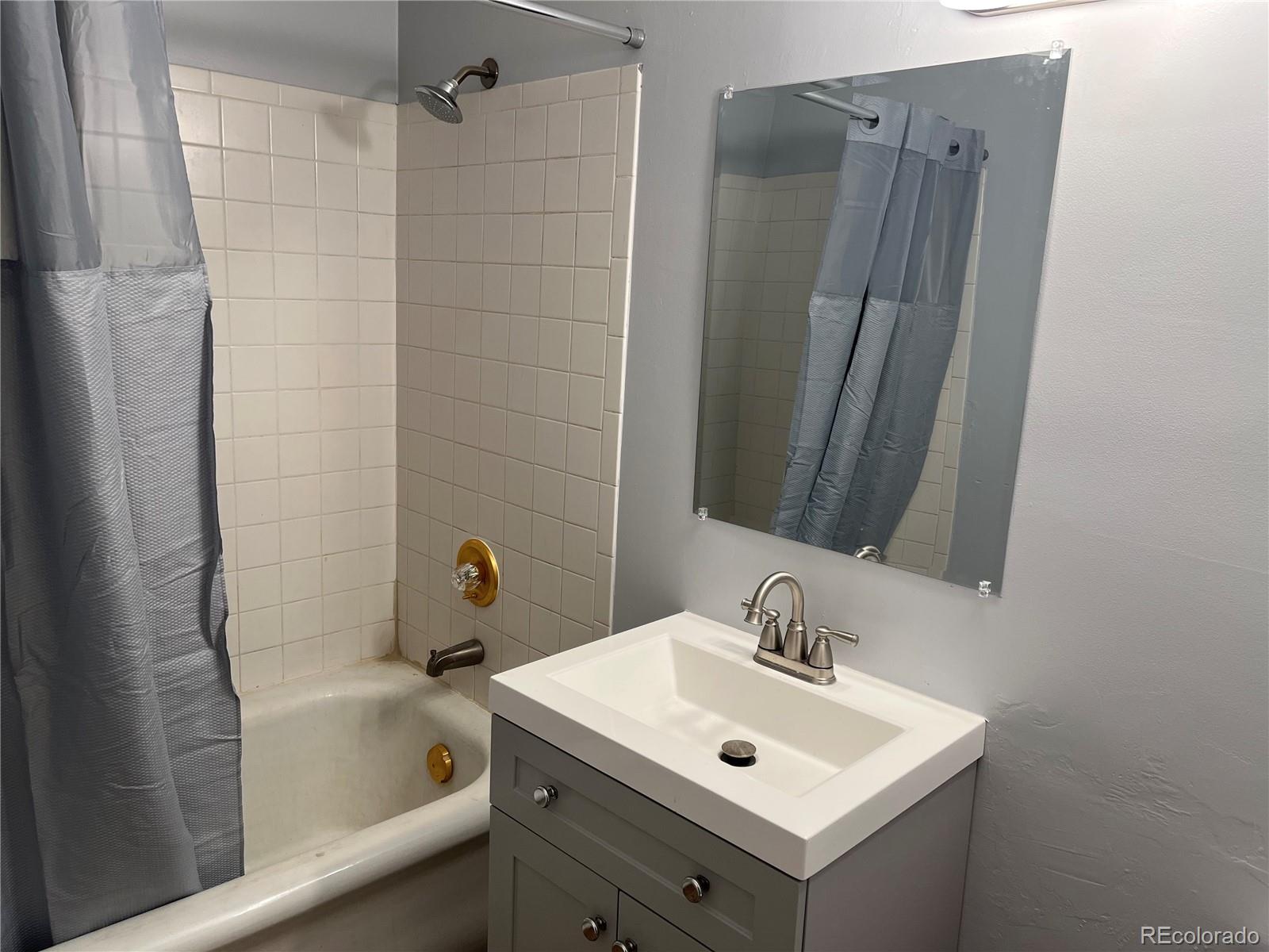 4315 Balsam Street, Unit A Wheat Ridge, CO 80033 - Photo 11 of 21 a bathroom with a sink and mirror with bathtub