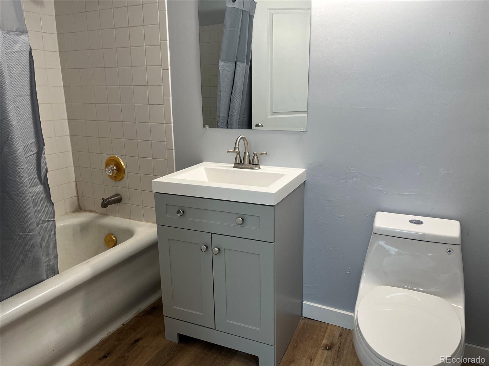 4315 Balsam Street, Unit A Wheat Ridge, CO 80033 - Photo 10 of 21 a bathroom with a sink toilet a tub and mirror