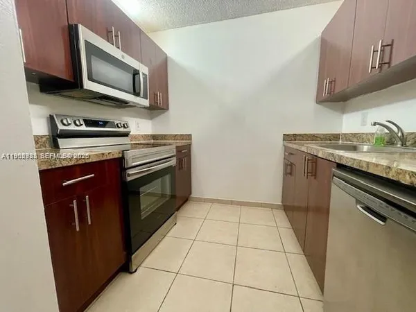 a kitchen with stainless steel appliances granite countertop a stove microwave and sink