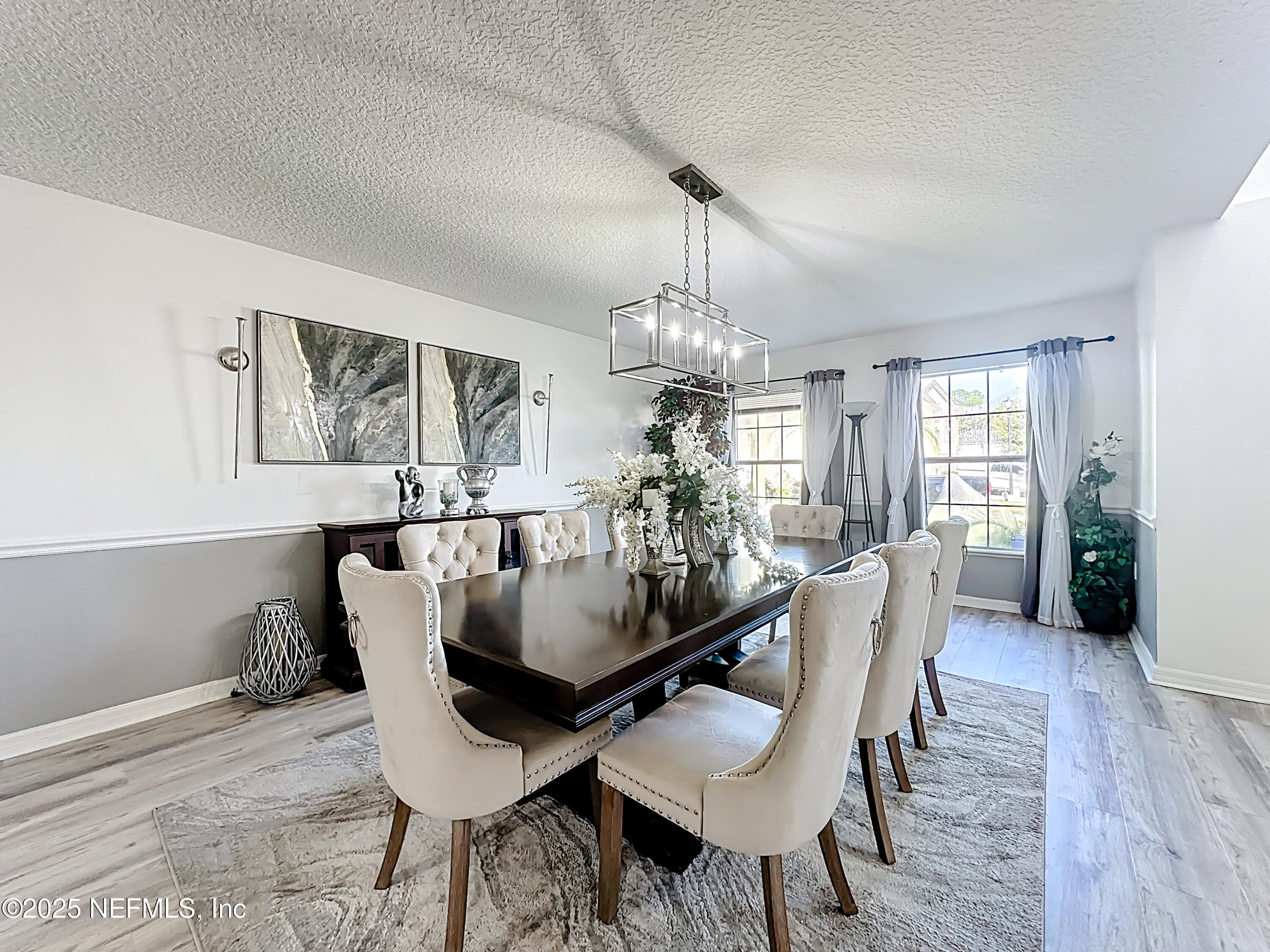 11939 Iron Creek Road Jacksonville, FL 32218 - Photo 11 of 73 a view of a dining room with furniture wooden floor and chandelier
