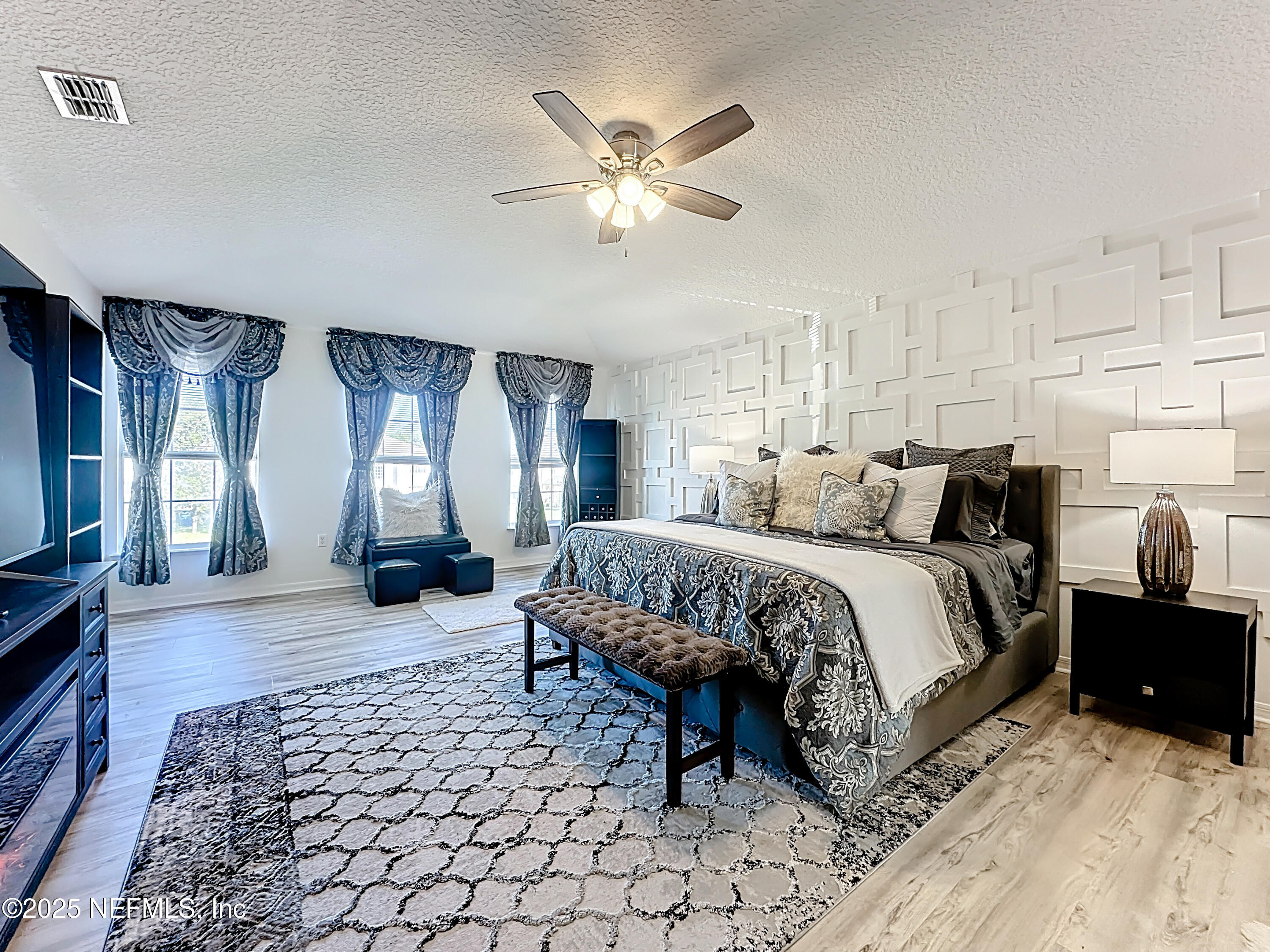 11939 Iron Creek Road Jacksonville, FL 32218 - Photo 50 of 73 a spacious bedroom with a bed and a chandelier