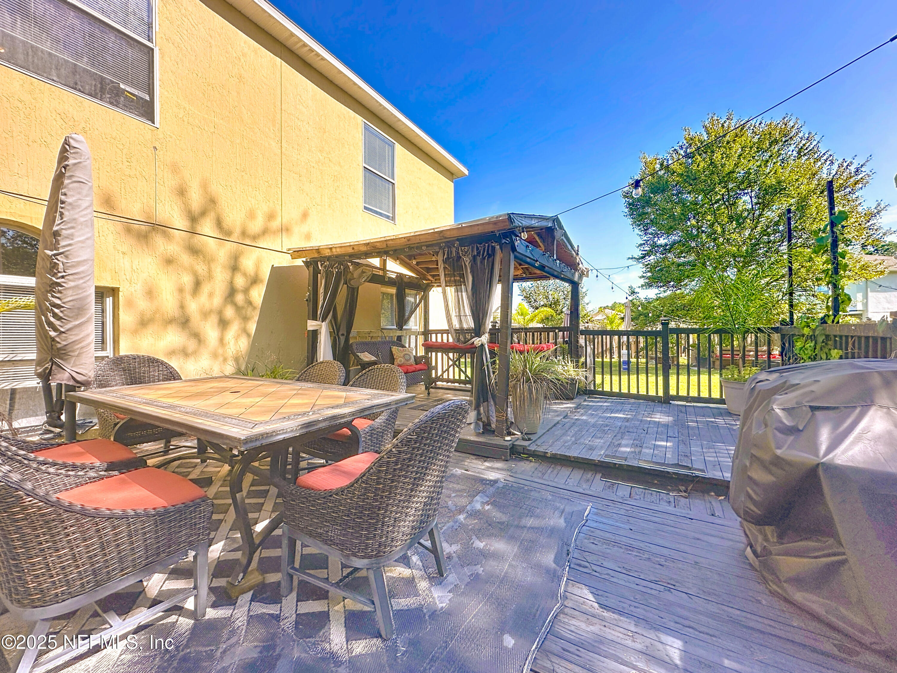 11939 Iron Creek Road Jacksonville, FL 32218 - Photo 63 of 73 a view of a patio with table and chairs with wooden floor and fence