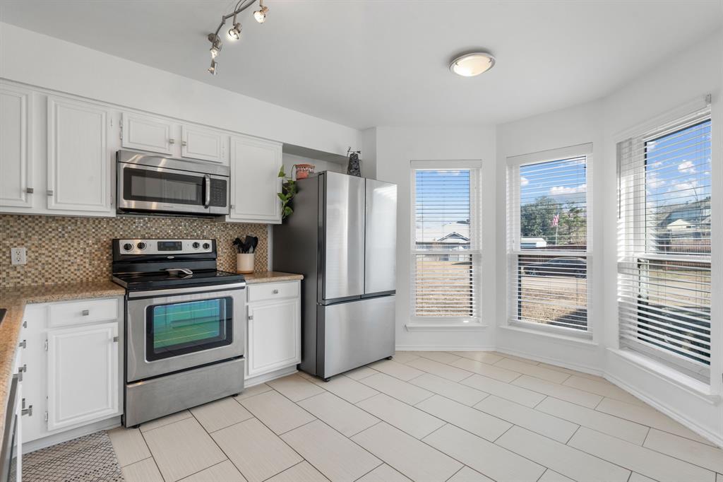 604 Lionel Way Fort Worth, TX 76108 - Photo 13 of 36 a kitchen with granite countertop a refrigerator and a stove top oven