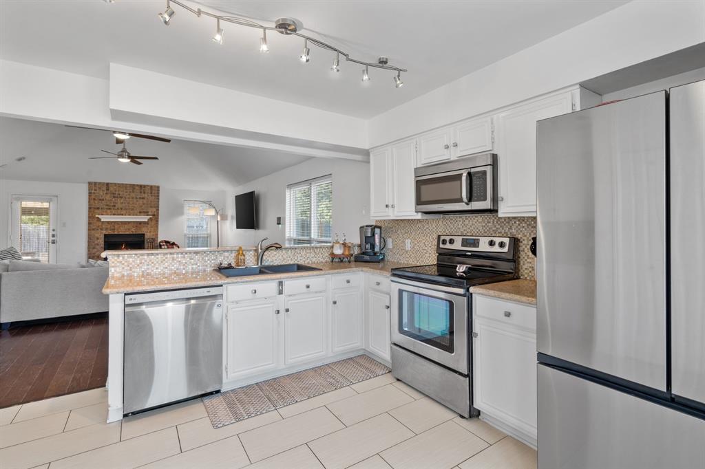 604 Lionel Way Fort Worth, TX 76108 - Photo 14 of 36 a kitchen with stainless steel appliances granite countertop a stove top oven a sink dishwasher a refrigerator and a microwave oven