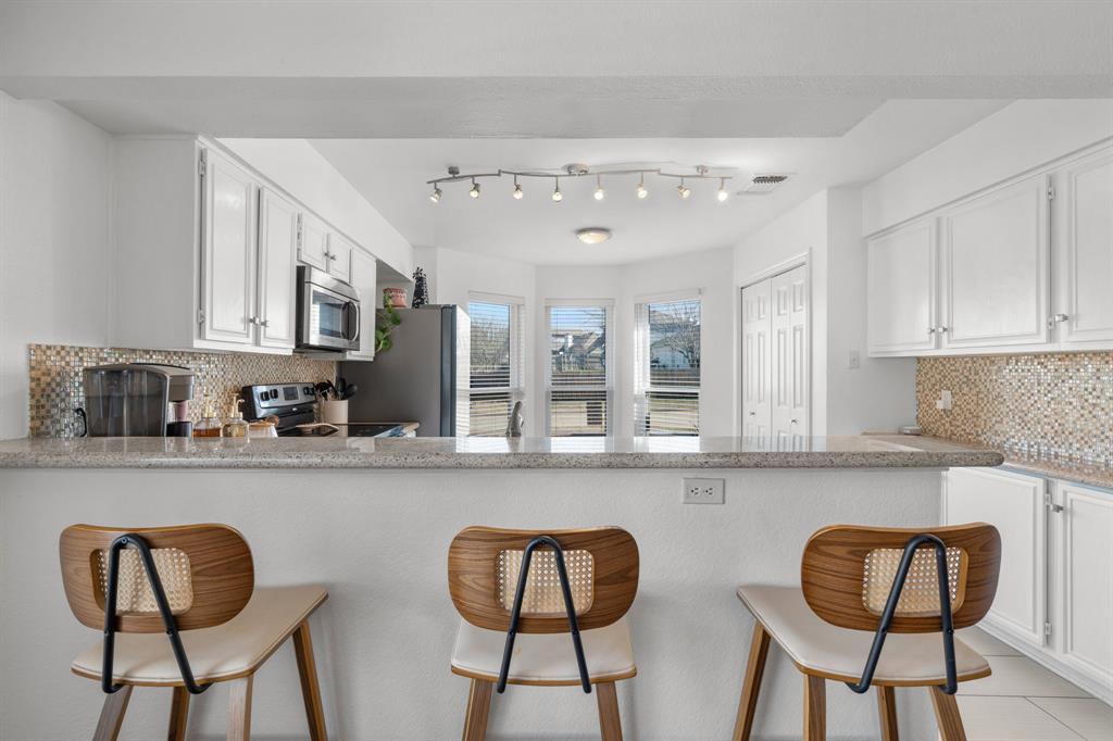 604 Lionel Way Fort Worth, TX 76108 - Photo 17 of 36 a kitchen with stainless steel appliances granite countertop a dining table chairs and cabinets