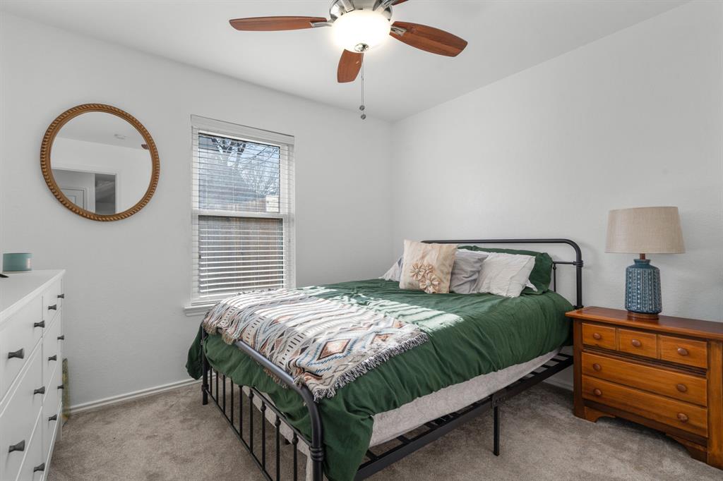 604 Lionel Way Fort Worth, TX 76108 - Photo 20 of 36 a bedroom with a bed and a chandelier