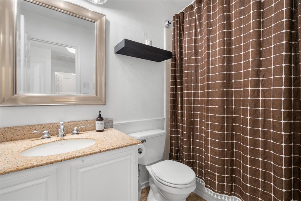 604 Lionel Way Fort Worth, TX 76108 - Photo 22 of 36 a bathroom with a granite countertop toilet a sink and a mirror